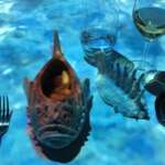 Ein fischförmiger Teller voller Fisch-Köstlichkeiten steht neben Gabel, Messer und Löffel sowie zwei Gläsern mit erfrischenden Getränken auf einem Tisch, der elegant mit einem blauen, wasserähnlichen Muster geschmückt ist.