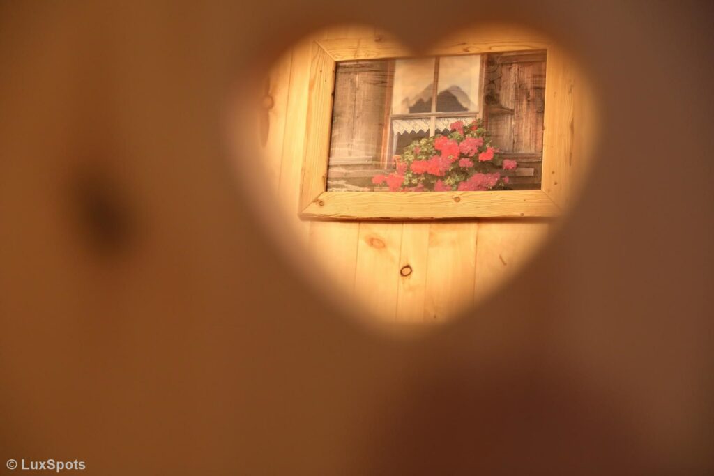 Blick durch ein Herz auf ein Bild im Alm-Chalet Prechtlgut