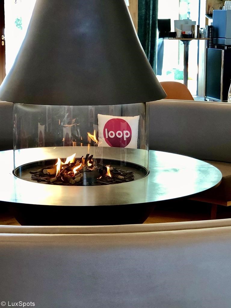 Moderner runder Kamin mit durch Glas eingeschlossenen Flammen in einem Raum.